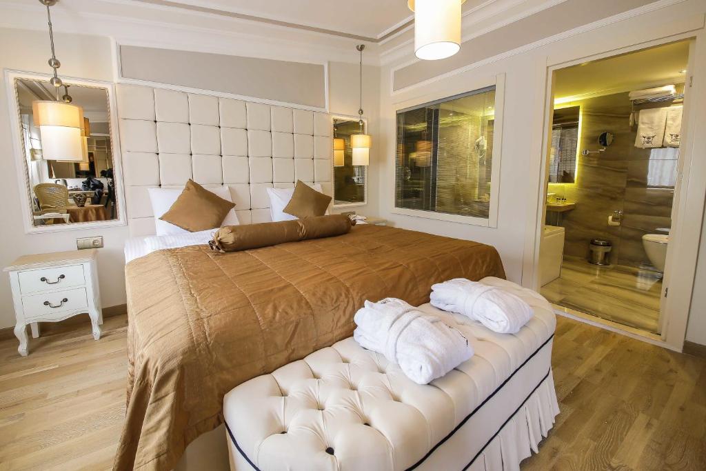 イスタンブールにあるザ コンスタンティン ホテルのベッドルーム(大型ベッド1台、白いソファ付)