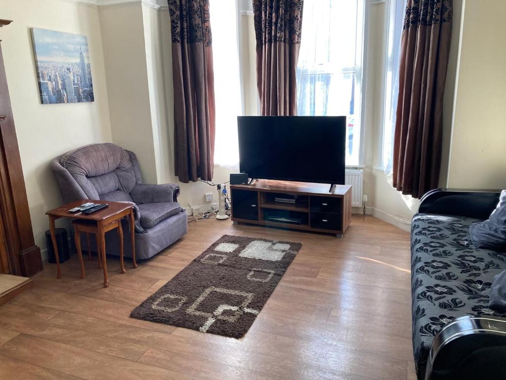 a living room with a tv and a couch and a chair at Chorlton Townhouse in Manchester