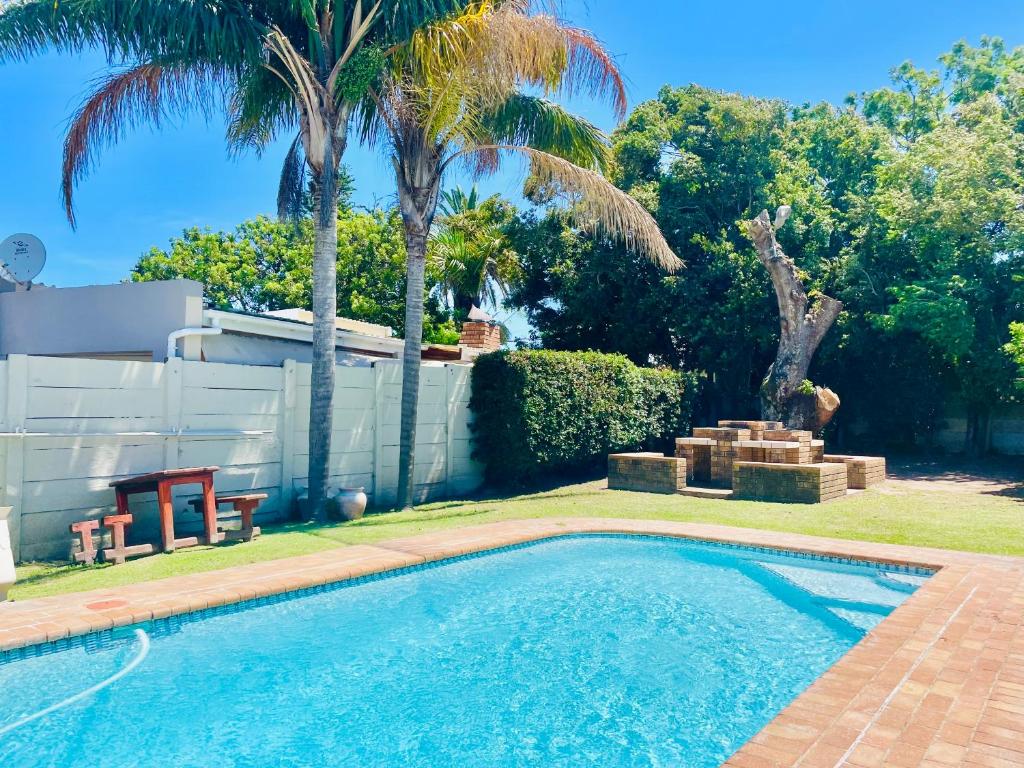 a swimming pool in a yard with palm trees at Entire House in Beacon Bay - Family or Group Retreat - Swimming Pool - Multiple Braais in East London
