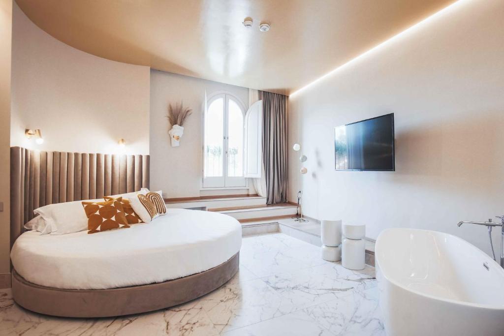 a bedroom with a bed and a tub and a tv at Hotel City Palazzo Dei Cardinali in Rome