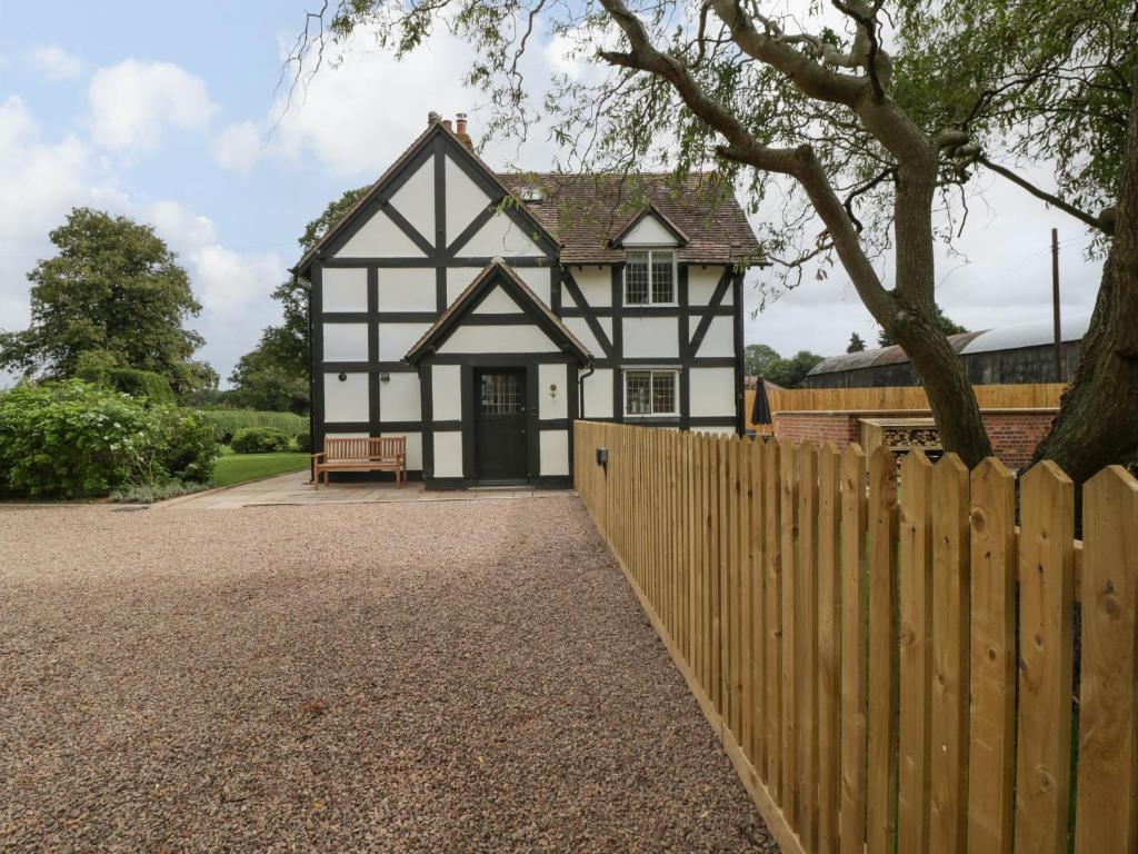 a black and white house with a wooden fence at Lavender Cottage in Malvern Link