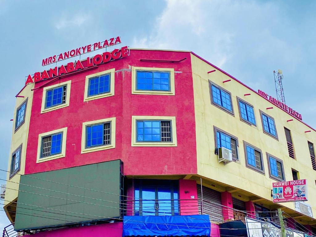 a red and yellow building with a sign on it at Abanaba lodge& Restaurant in Kumasi