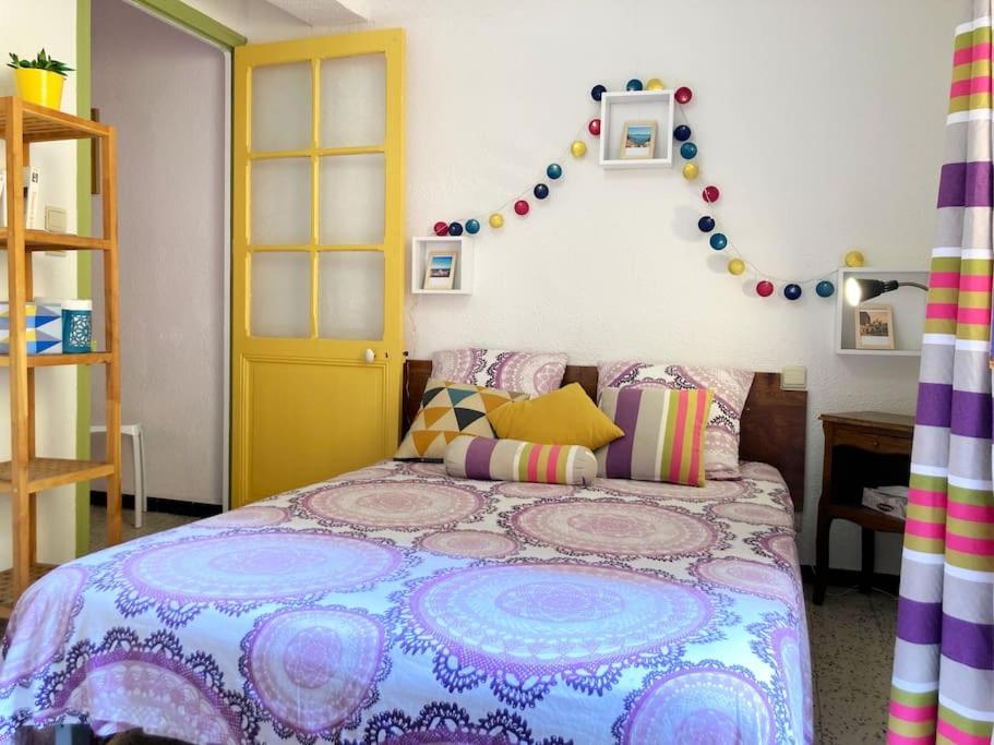 - une chambre avec un lit et une couverture colorée dans l'établissement À deux pas de la plage, à Collioure