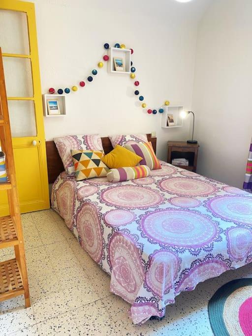 a bedroom with a bed with a colorful blanket at À deux pas de la plage in Collioure