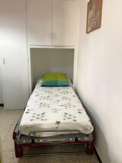 a small bed in a corner of a room at À deux pas de la plage in Collioure