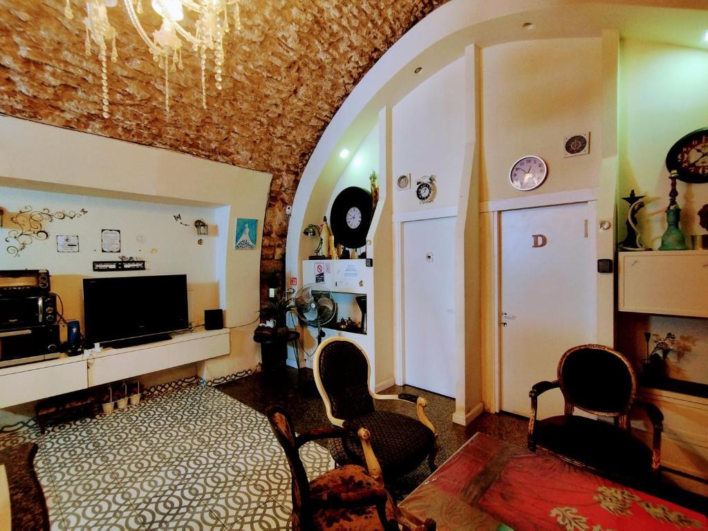 a living room with a tv and chairs and an archway at PoliHosts Old Jaffa in Tel Aviv
