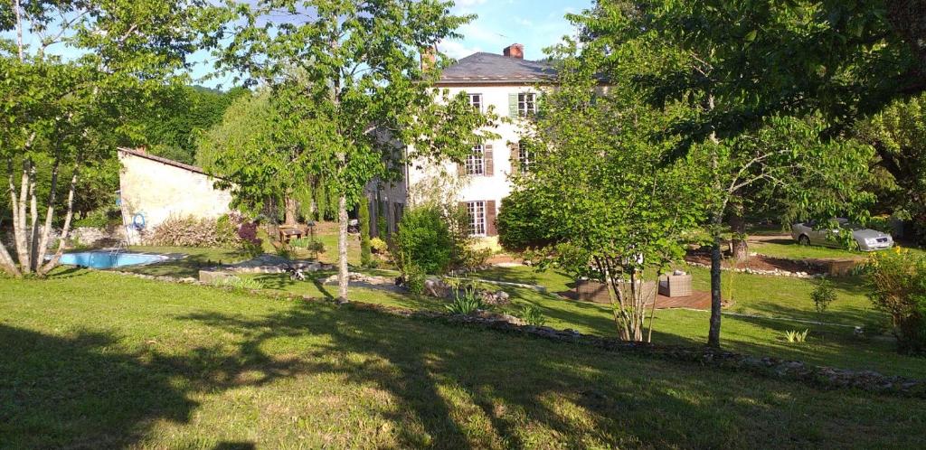 een groot wit huis met een tuin met bomen bij Le CLOS BOURBON in Ferrières-sur-Sichon