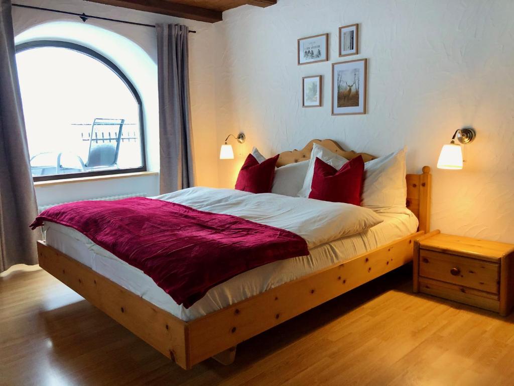 - une chambre avec un grand lit et des oreillers rouges dans l'établissement Chesa-strimer - Terrassa, à La Punt-Chamues-ch