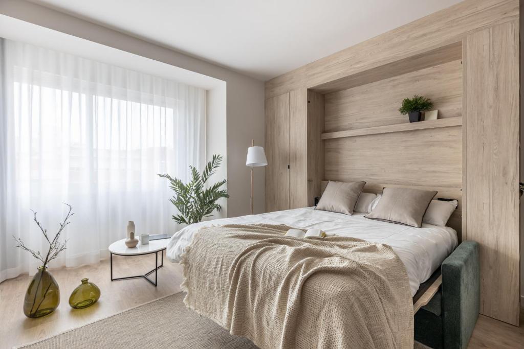 a bedroom with a large bed with a wooden headboard at Líbere Madrid Chamberí in Madrid