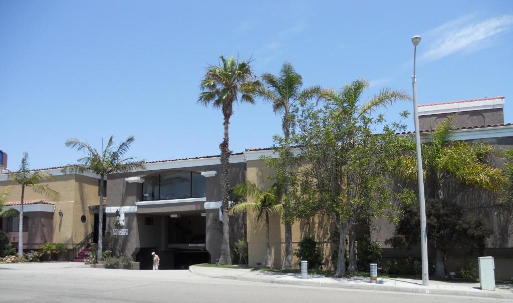 un edificio con palme di fronte a una strada di Hotel Pacific, Manhattan Beach a Manhattan Beach