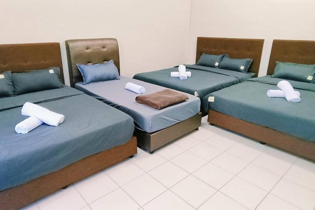 Habitación con 3 camas y almohadas. en kulai2story 5R24pax nearJPO/JB airport ioiMall Aeon, en Kulai