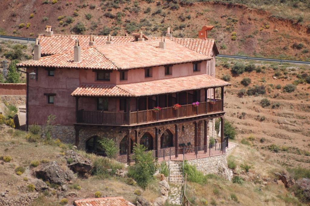 een groot huis aan de zijkant van een heuvel bij La Posada De Santa Ana in Tramacastilla