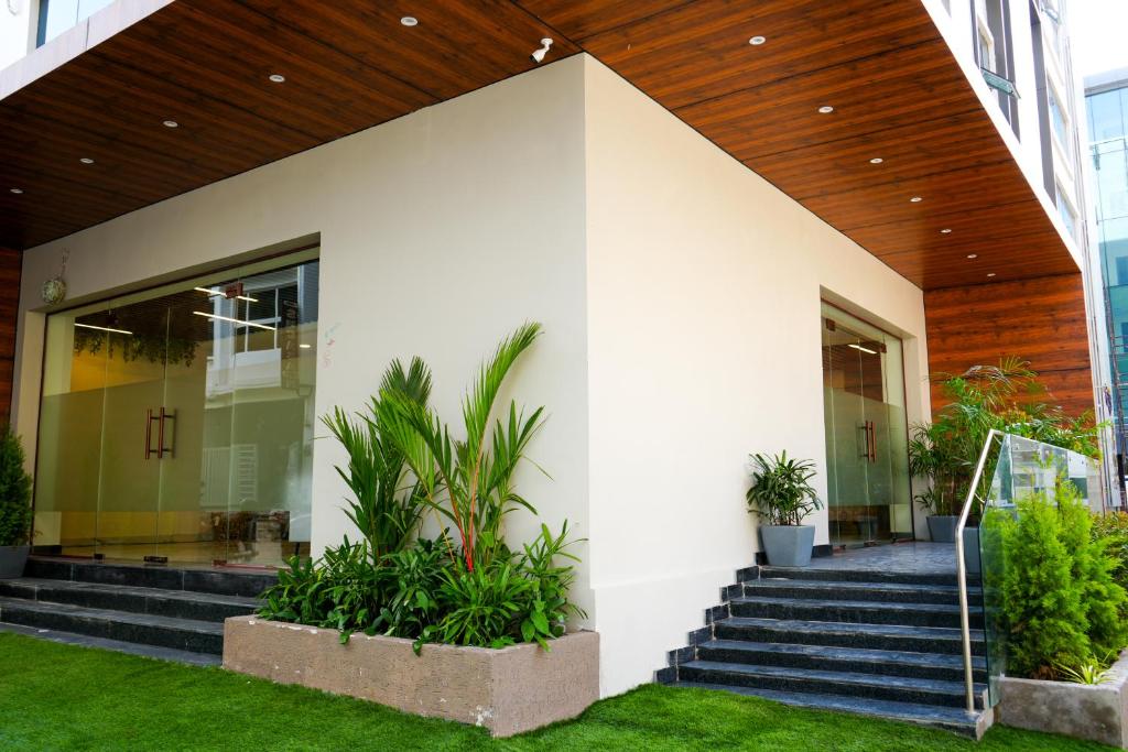 a white building with stairs and plants at Casa Hotel & Suites, Gachibowli, Hyderabad in Hyderabad