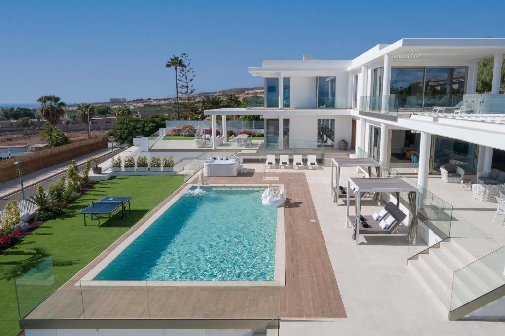ein großes weißes Haus mit einem Pool in der Unterkunft KARAT Villa Royal White in Adeje