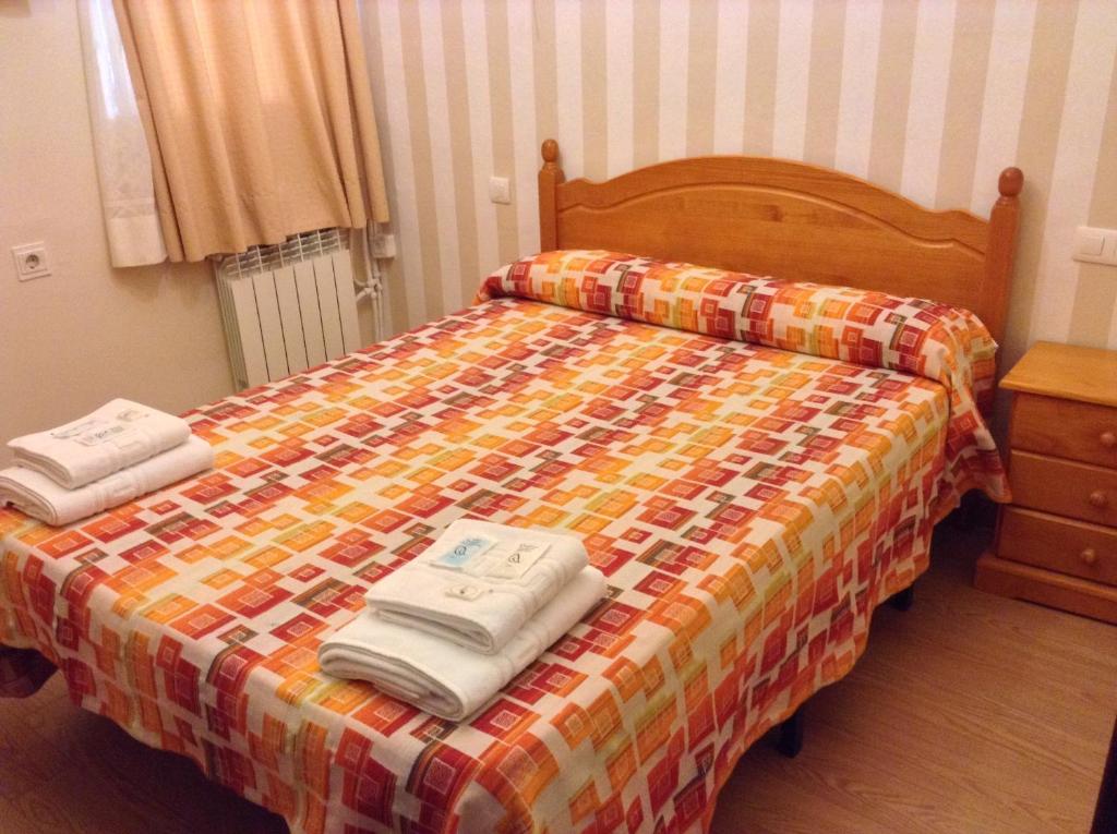 een slaapkamer met een bed met twee handdoeken erop bij Pension La Milagrosa in Granada
