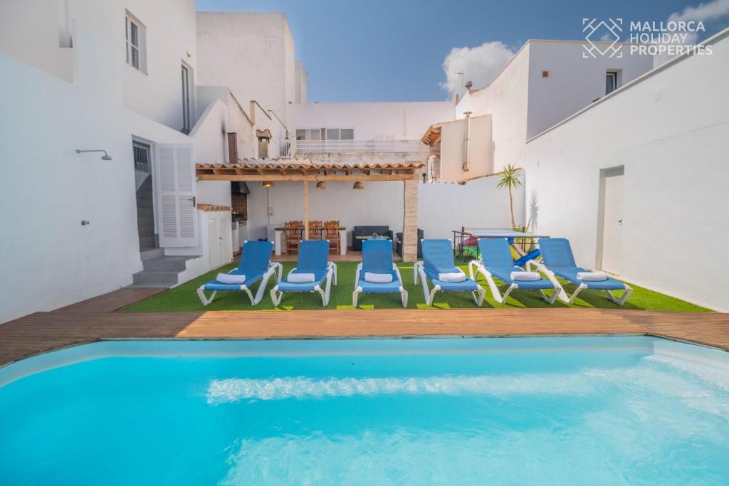 a villa with a swimming pool and blue chairs at Villa Fonte in Port de Pollensa