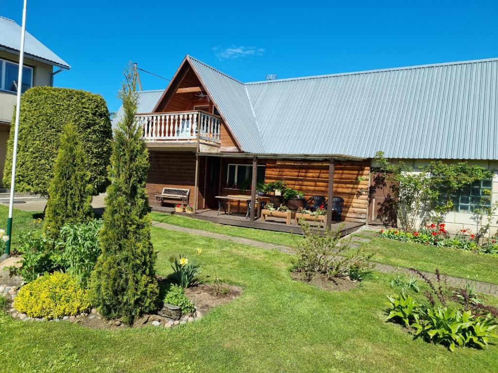 una casa de madera con terraza y patio en Põlluotsa Guest House, 