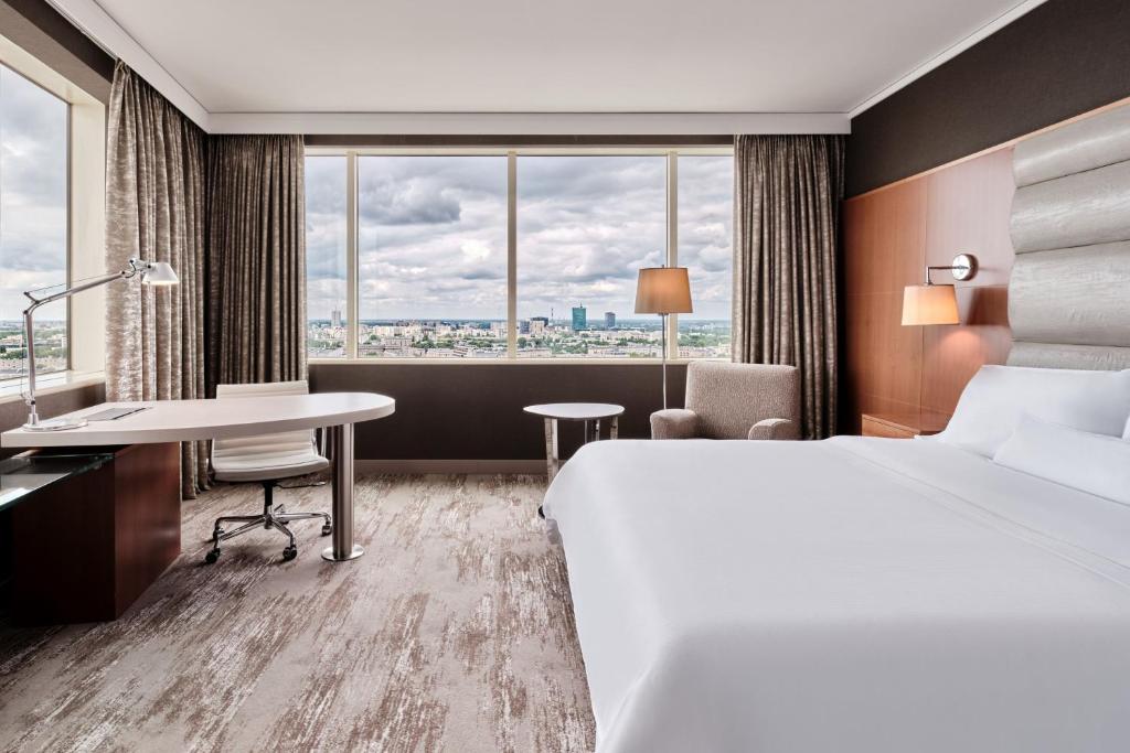 a hotel room with a bed and a desk and a window at The Westin Warsaw in Warsaw