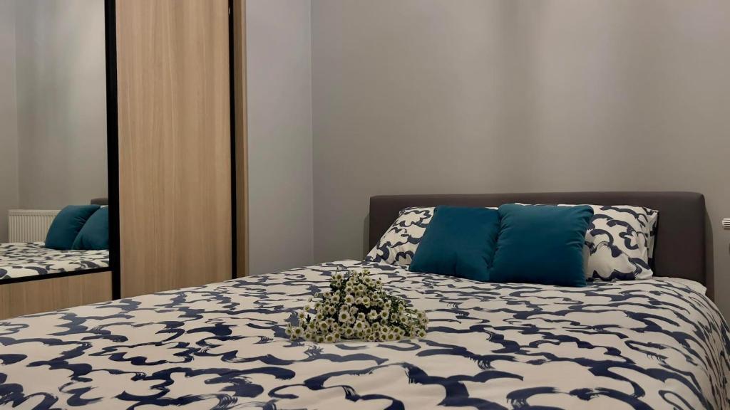 Schlafzimmer mit einem Bett mit einer blauen und weißen Bettdecke in der Unterkunft Parkcity Kraków in Krakau