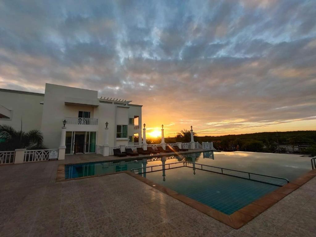 a villa with a swimming pool at sunset at Krabi Front Bay Resort in Krabi