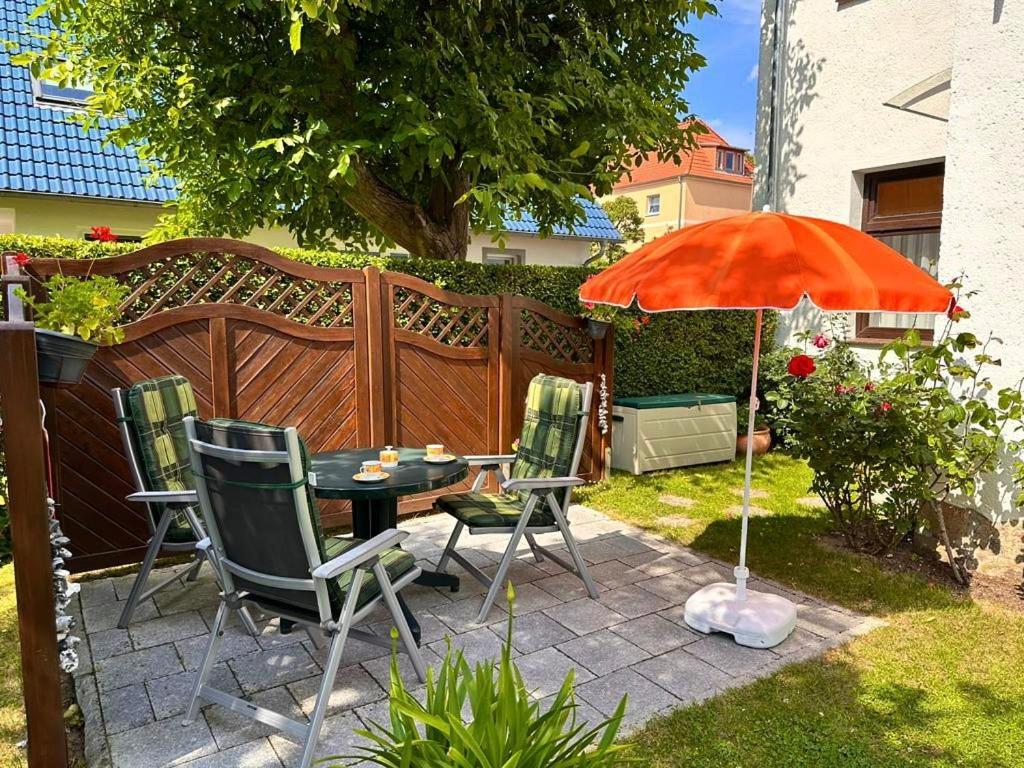 a patio with a table and chairs and an umbrella at Ferienwohnung Seerose in Sassnitz