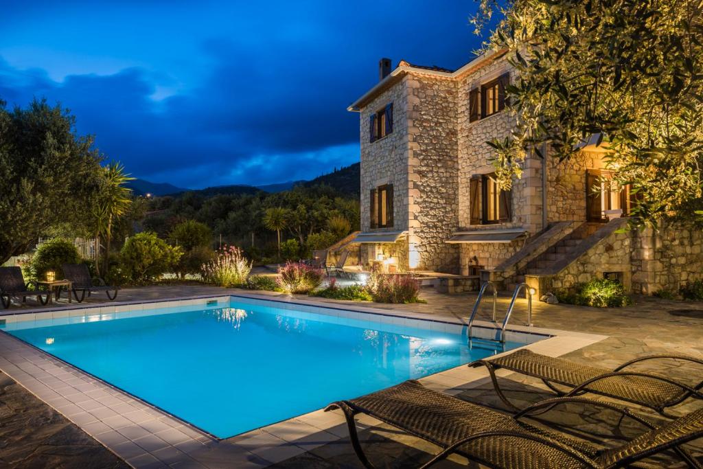 a villa with a swimming pool in front of a building at Eleonas Houses - Kardamili's Acqua Bliss in Kardamyli