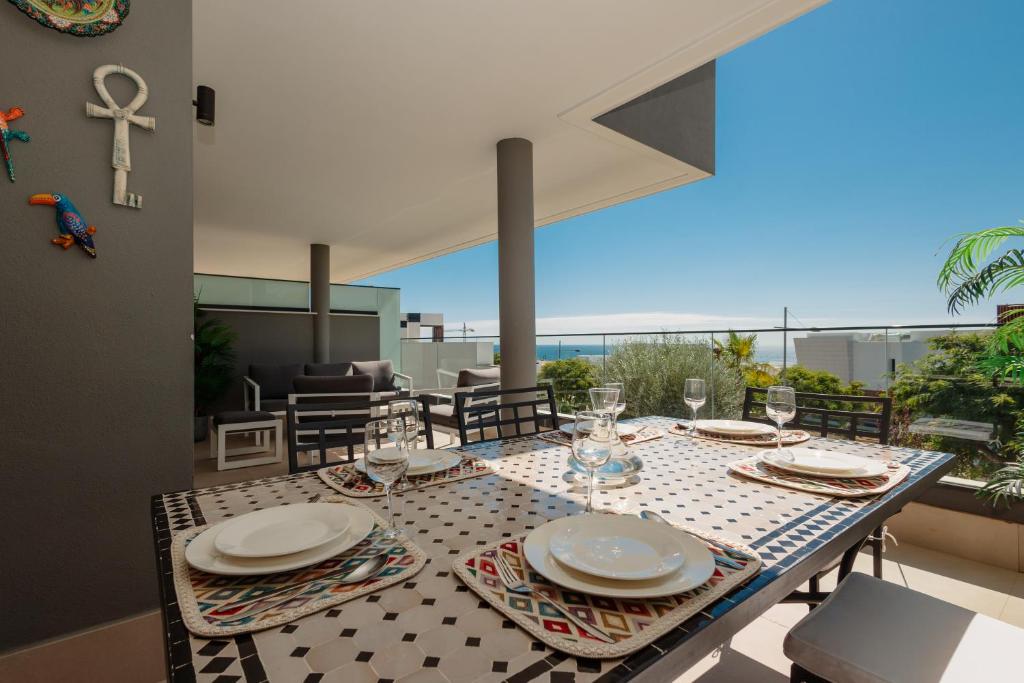 stół z talerzami i kieliszkami do wina na balkonie w obiekcie Magnificent apartment, close to the beach, in Estepona w mieście Estepona