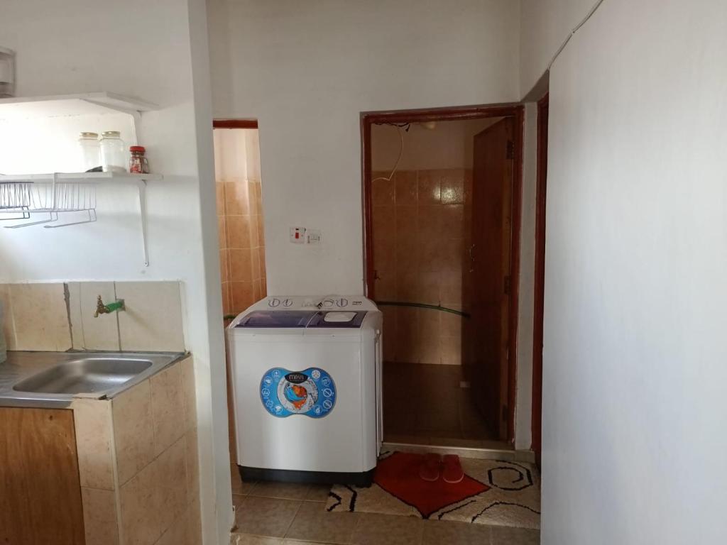 uma pequena cozinha com um lavatório e um frigorífico em Bosslady Staycation C1 em Muchatha