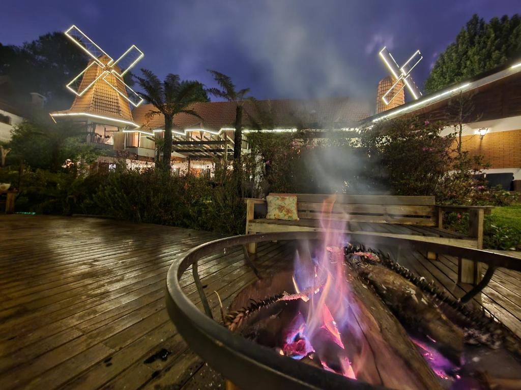 a fire pit in a patio with a bench and a fire pit at Recanto dos Moinhos - Boutique Hotel in Campos do Jordão