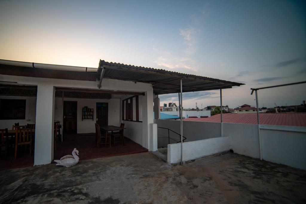 a house with a patio and a swan sitting on a roof at Flamingo Guest House ZNZ in Stone Town