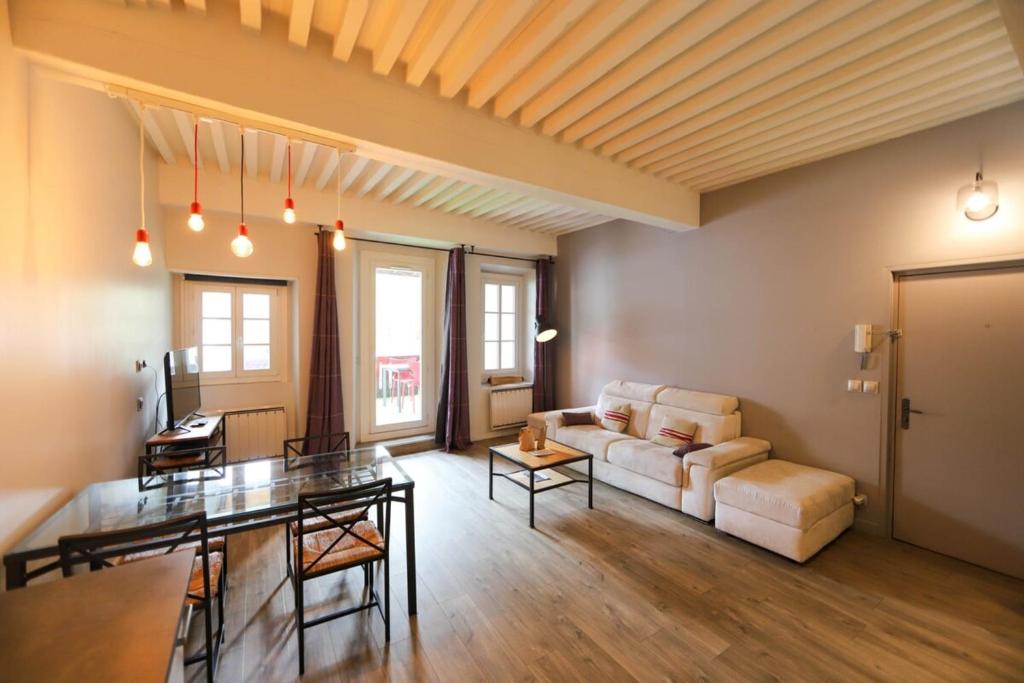 55 m2 Apart with big terrace in Annecy downtown في أنِسي: غرفة معيشة مع أريكة وطاولة