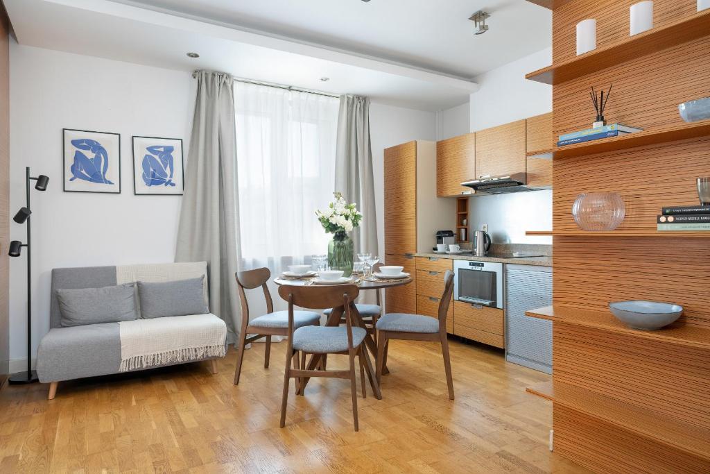 uma cozinha e sala de jantar com mesa e cadeiras em Beautiful Apartment Aleje Marcinkowskiego with Balcony by Renters em Poznań