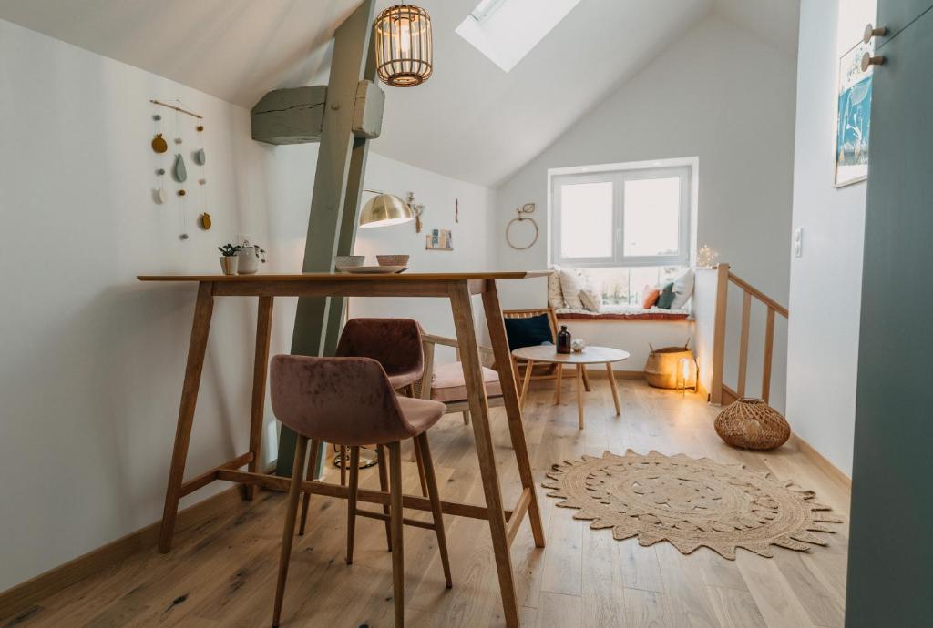 a room with a table and chairs in a room at Grange Petite Brise bord de mer in Luc-sur-Mer