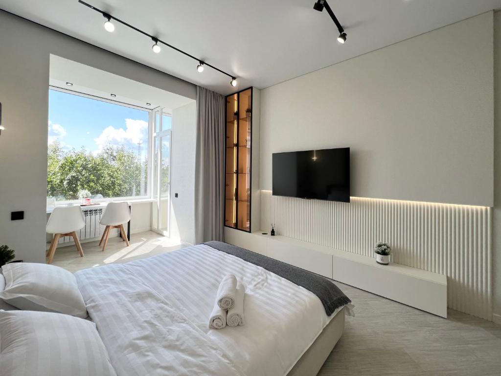 sypialnia z dużym łóżkiem z telewizorem na ścianie w obiekcie LUX Апартаменты SMART #7 w mieście Pawłodar