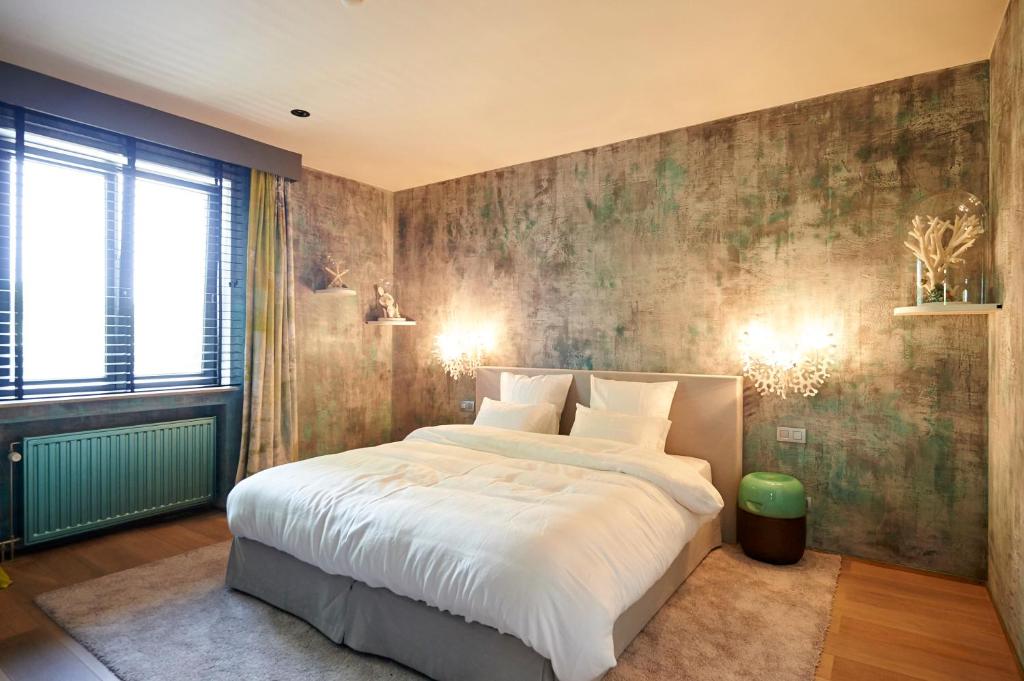 a bedroom with a large bed and a large window at Hotel Groenendaal in Hoeilaart