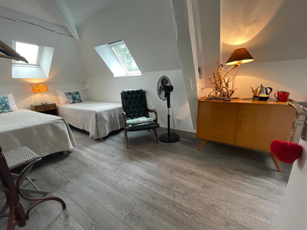 a bedroom with two beds and a desk and a chair at Les rêves d'Angèle in Crain