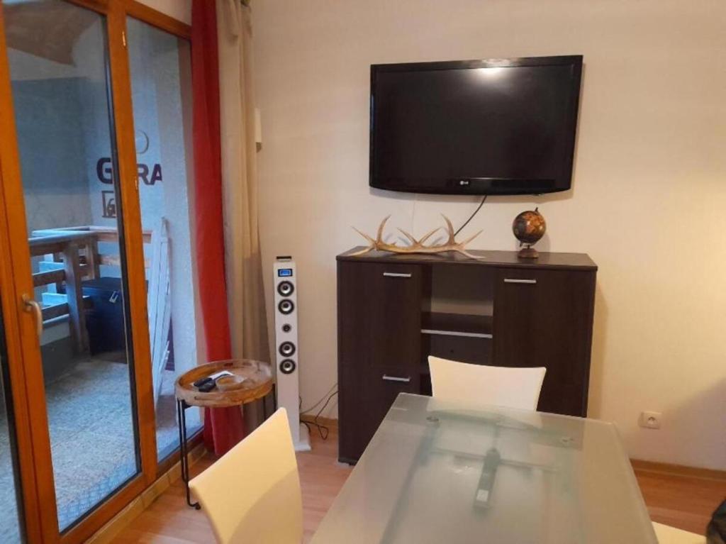 a room with a table and a television on a wall at studio montagne in Les Orres