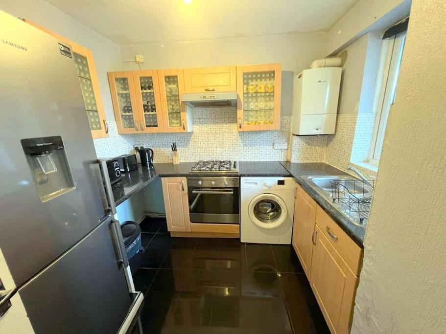 a kitchen with a washing machine and a washer at 2-bedroom Flat in Sydenham in Forest Hill