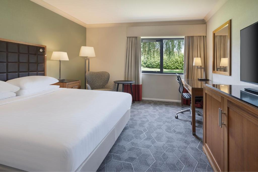ein Hotelzimmer mit einem großen Bett und einem TV in der Unterkunft Delta Hotels by Marriott Peterborough in Peterborough