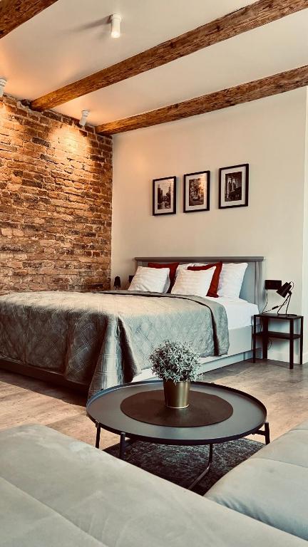 a bedroom with a large bed and a brick wall at Apartamenty Katowicka 38 in Świętochłowice