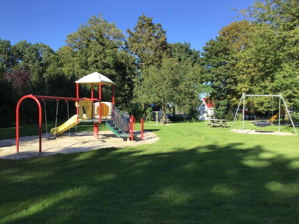 een park met een speeltuin met een glijbaan en schommels bij Vakantiehuis ontdek Zuid - Limburg in Simpelveld