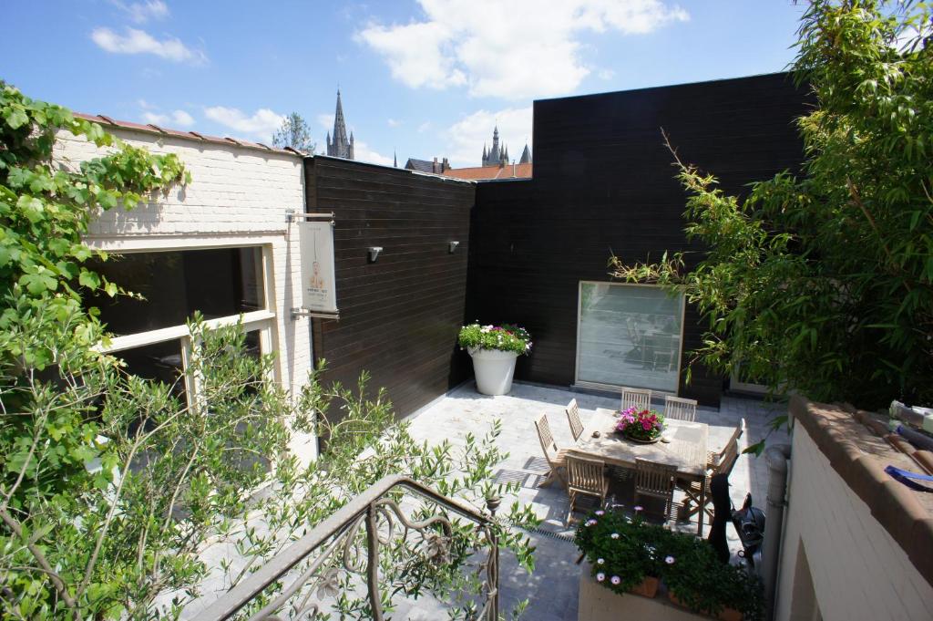 a patio with a table and chairs and a building at B&B Wellness Yoake in Ypres