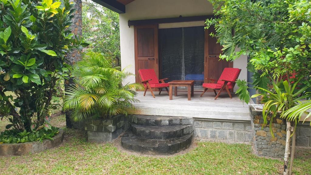 una casa con 2 sillas y una mesa en un porche en Les Citronniers en Isla Santa María