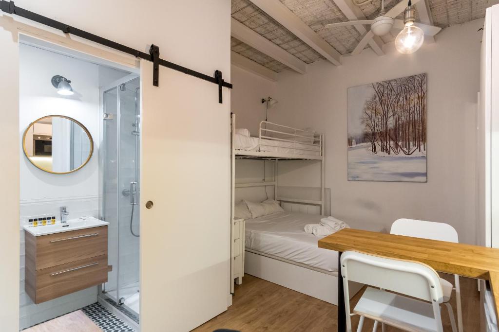 a small bedroom with a bed and a desk and a mirror at Cozy studio - 1Bathroom - Chamberí in Madrid