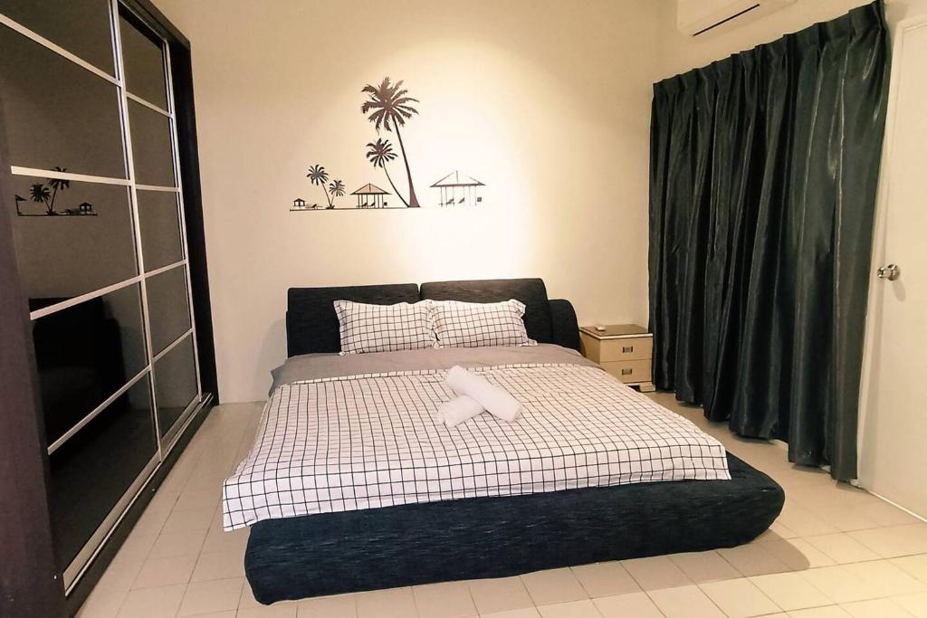 Un dormitorio con una cama con una toalla. en 1399 Kulai 12pax 5BR double StoryHouse Near JPO, Airport, AEON en Kulai