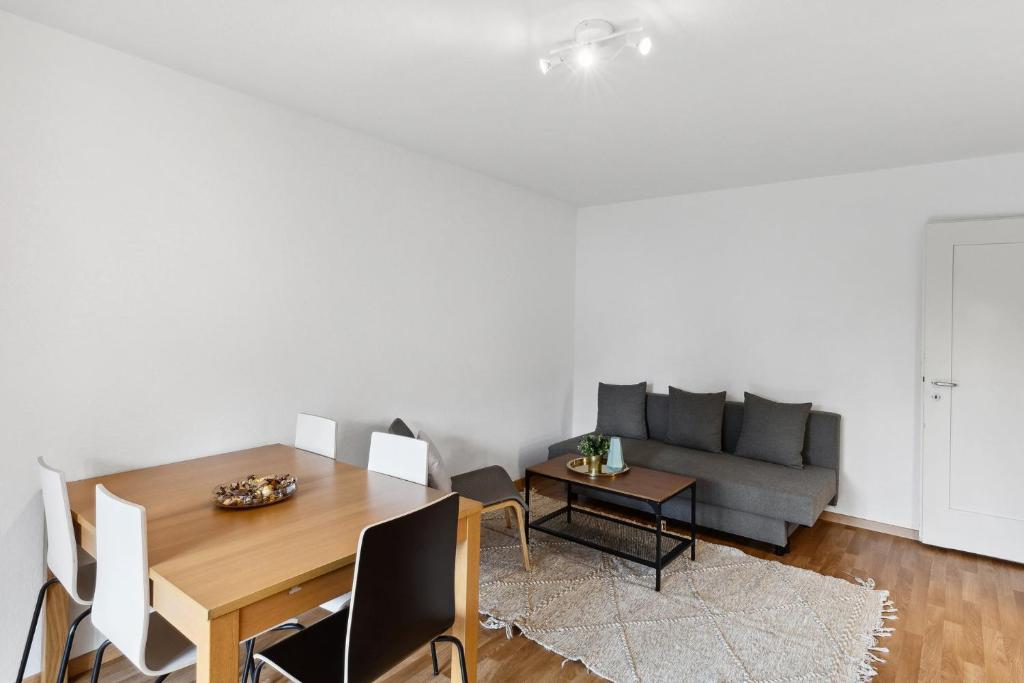 een woonkamer met een tafel en een bank bij Zurich Urban Charm: Your comfy stay close to the City in Zürich