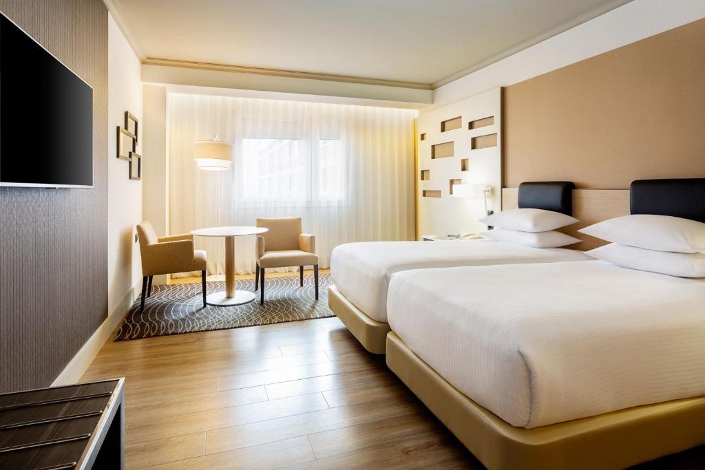 A bed or beds in a room at Madrid Marriott Auditorium Hotel & Conference Center
