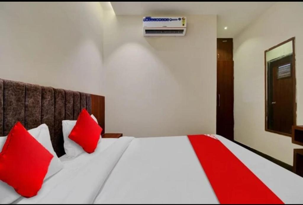 Hotel Maharaja في أودايبور: غرفة نوم بسرير ومخدات حمراء