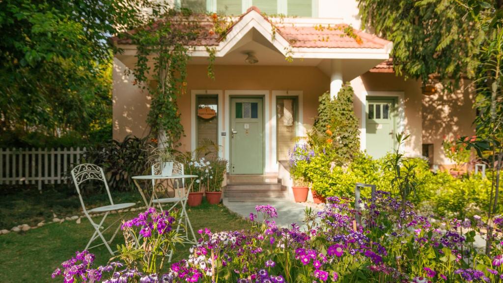 a house with a table and chairs and flowers at Karma Chalets in Gurgaon