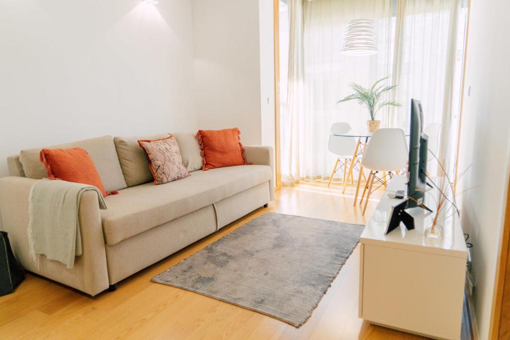 a living room with a couch and a tv at Oporto Yellow Apartments in Porto